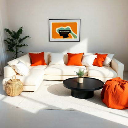 A bright, minimalistic living room with a cream sectional sofa, orange cushions, and a framed surreal silhouette piece showcasing dynamic teal waves.